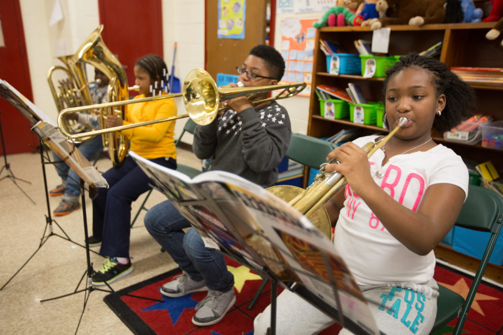 Four students playing brass instruments